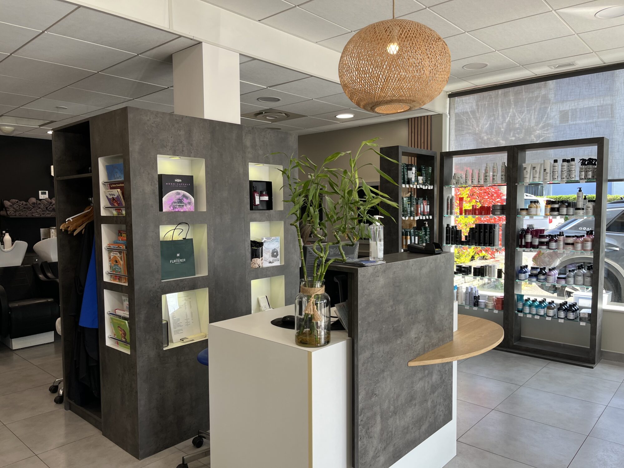 Photo de l'accueil du salon Espace Détente Coiffure avec le mur de produits partenaires en arrière plan