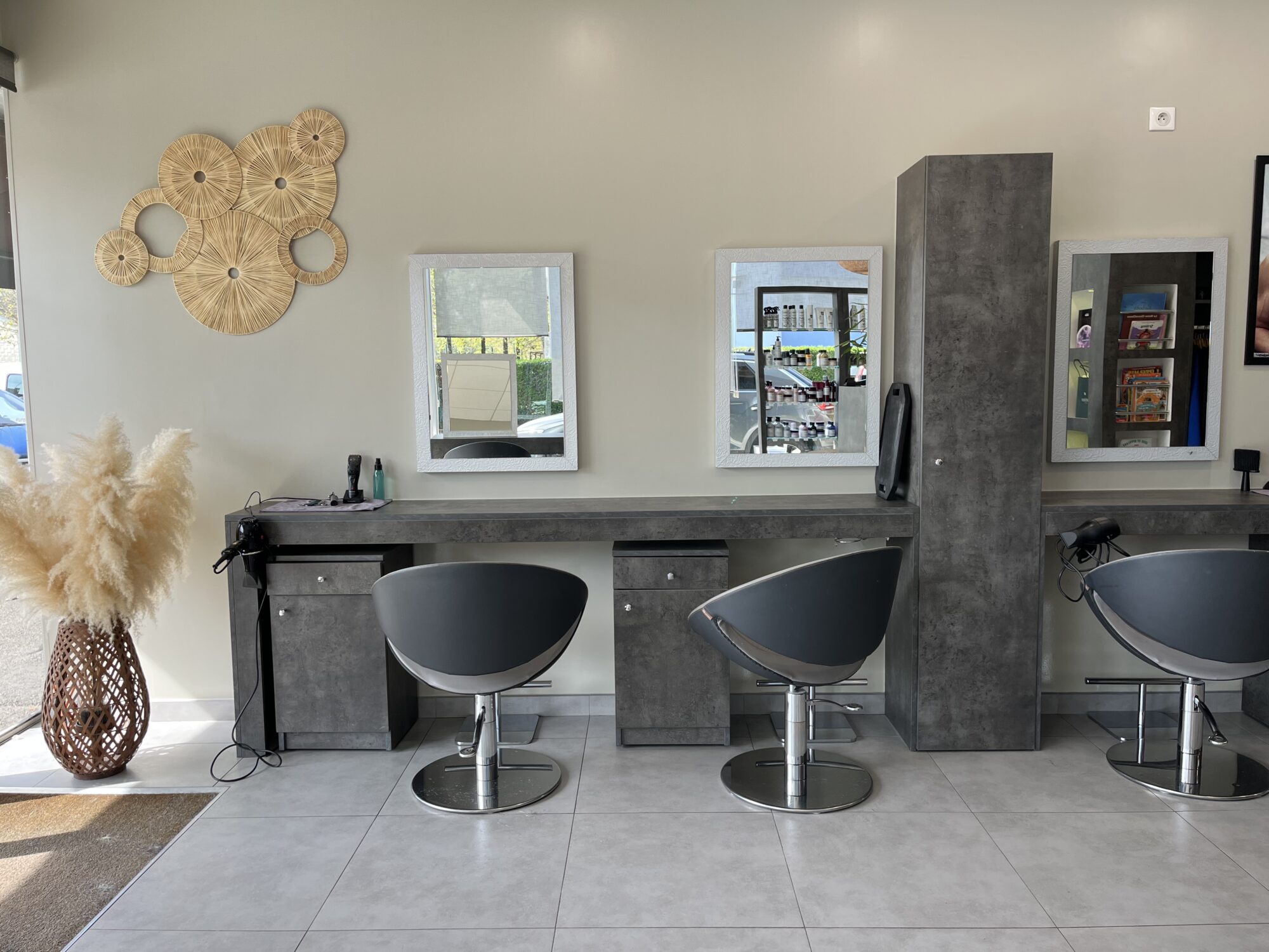 Photo des sièges de coiffure situés à l'entrée du salon, deux fauteuils devant coiffeuses avec miroir